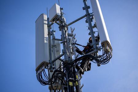 Ein Techniker führt Reparaturarbeiten an 5G-Antennen durch. Ein Techniker führt Reparaturarbeiten an 5G-Antennen durch.