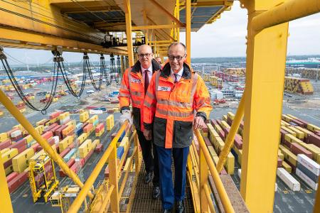 Hoffentlich schwindelfrei: Bundeskanzler Friedrich Merz und Bremens Bürgermeister Andreas Bovenschulte (SPD) stehen auf einer Containerbrücke im Überseehafen in Bremerhaven.