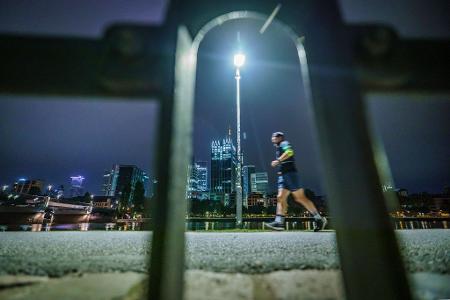 Frühsport in der Banken-Stadt: Ein Jogger läuft am frühen Morgen vor der Skyline von Frankfurt am Main.