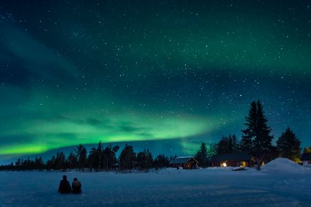Polarlichter über einem Ort in einer Schneelandschaft