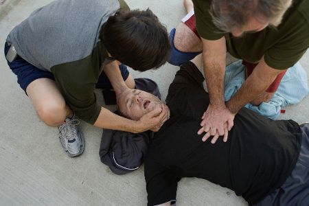 Zwei Personen machen Herzdruckmassage bei einem Bewusstlosen