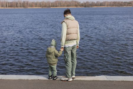 Mann und ein kleiner Junge stehen am Wasser