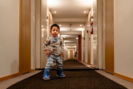 Kleiner Junge alleine in einem Hotelflur