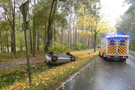 Der Unfallwagen auf dem Dach liegend im Grünstreifen