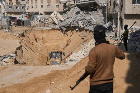 Mitglieder der militanten Hamas-Gruppe graben nach den Leichen israelischer Geiseln inmitten zerstörter Gebäude im südlichen Gazastreifen.