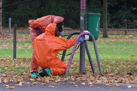 Feuerwehrleute überprüfen eine Mülltonne. Feuerwehrleute überprüfen eine Mülltonne.