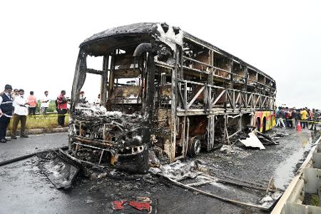 Die verkohlten Überreste des Passagierbusses liegen auf einer Landstraße im Dorf Chinnatekuru. Die verkohlten Überreste des Passagierbusses liegen auf einer Landstraße im Dorf Chinnatekuru.