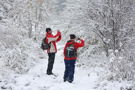 Der Winter kommt: Wanderer sind auf dem verschneiten Brocken unterwegs und genießen die Winterlandschaft.