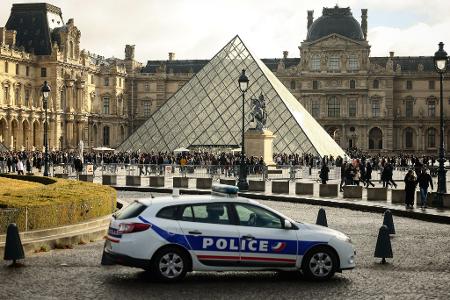 Ein Polizeiauto parkt im Hof des Louvre. Eine Woche nach dem spektakulären Kunstraub im Pariser Louvre hat es zwei Festnahmen gegeben. 