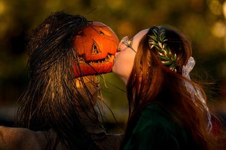 Ein Mädchen posiert für einen Freund und küsst einen Kürbis auf dem West Side Hallo Fest, dem größten Halloween-Festival des Landes, in Bukarest.