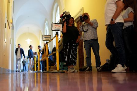 Kamerateam steht auf dem Flur vor einem Gerichtssaal