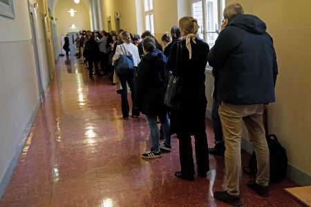 Menschen stehen in einem Gerichtsflur Schlange vor dem Gerichtssaal