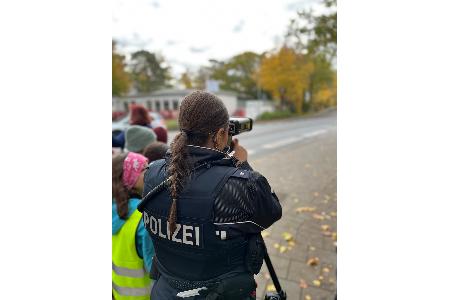 Eine Polizeibeamtin beim Messen der vorbeifahrenden Fahrzeuge.