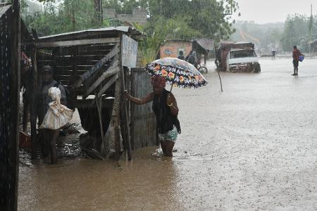 Anwohner waten durch eine überflutete Straße nach dem durchzug von Hurrikan Melissa in Petit-Goave.