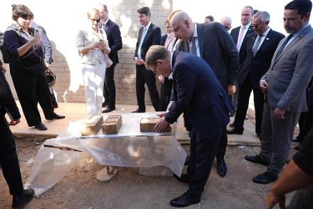 Außenminister Johann Wadephul (CDU) macht sich ein Bild von einem Projekt, das Binnenvertriebenen ermöglichen soll, günstig mit Lehmziegeln zu bauen. 