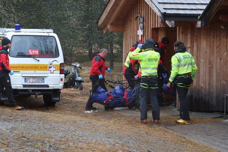 Zwei der Todesopfer werden zu einer Hütte getragen.
