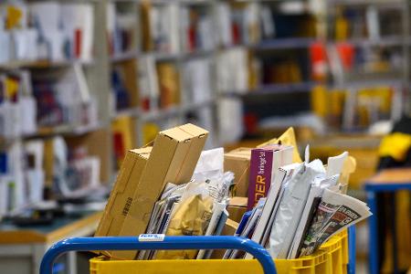 Briefe und Päckchen liegen in einem Zustellstützpunkt der Post - zuletzt transportierte der Postdienstleister mehr Briefe als gedacht. (Archivbild)