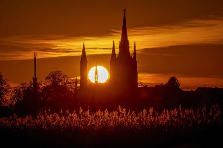 Hinter der Heilig-Geist-Kirche auf der Insel Werder geht die Sonne unter.