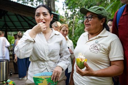 Bundesministerin Radovan (l) verkostet Kakaofrucht.