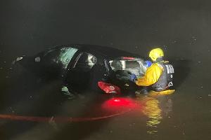 © Feuerwehr Dresden
Ein Einsatzschwimmer bringt eine Rundschlinge am Fahrzeug an, damit es im Anschluss aus dem Wasser gezogen werden kann.
