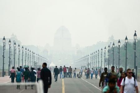 Menschen auf einer in Smog gehüllten Straße in Neu Delhi. (Archivbild)