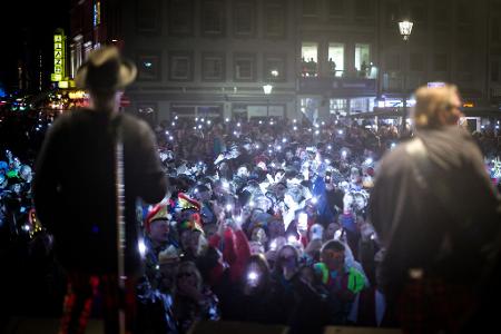 Bei einem Konzert der Kölner Band Brings in der Düsseldorfer Altstadt halten die Fans ihre Handylichter hoch.