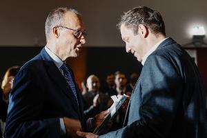 Ein Gespräch unter Kollegen: Regierungschef Merz und Vizekanzler Klingbeil unterhalten sich auf dem Empfang zu Merz' 70. Geburtstag.