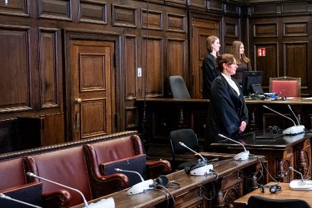 Die Verteidigerin steht zunächst ohne ihre Mandantin im Gerichtsaal, weil die wahrscheinlich psychisch kranke Beschuldigte erst hereingeführt wird, nachdem die Fotografen gegangen sind. 