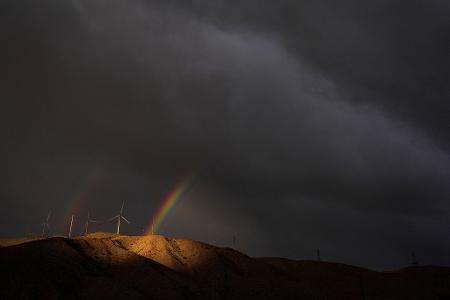 Ein doppelter Regenbogen erscheint hinter Windturbinen unter Gewitterwolken in der Nähe von Cathedral City in Kalifornien.