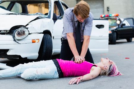 Mann macht Herz-Druck-Massage bei einer bewusstlosen Frau