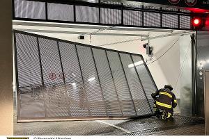 Ein Feuerwehrmann vor dem beschädigten Tor.