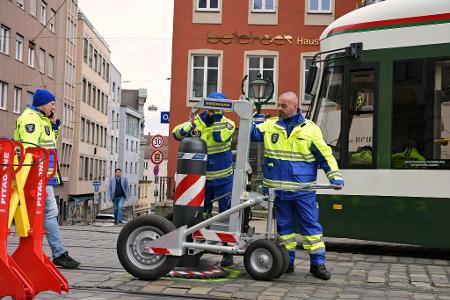 Zu den Hauptverkehrszeiten müssen Sicherheitsmitarbeiter neben dem Augsburger Christkindlesmarkt jede Stunde dutzendfach schwere Poller bewegen, damit die Straßenbahnen durchfahren können.