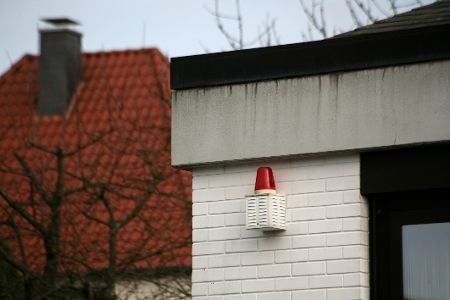 Alte Alarmanlage an einem Haus von außen