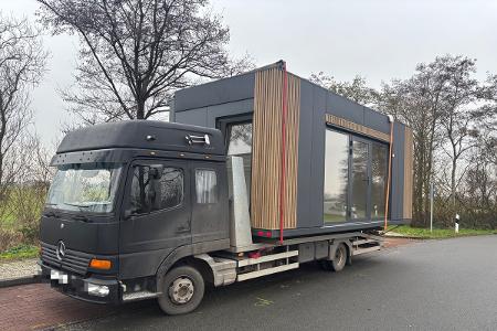 Fahrzeugtransporter mit aufgeladenem Tiny-House
