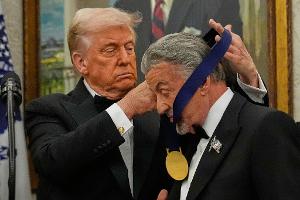 US-Präsident Donald Trump hängt der Actionfilm-Ikone Sylvester Stallone eine Medaille um. 