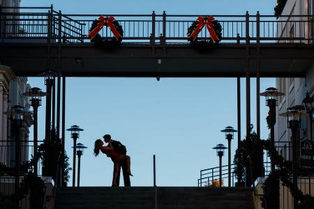 Ein Paar küsst sich an seinem einjährigen Hochzeitstag oben auf den Stufen der Jax Brewery im French Quarter von New Orleans.