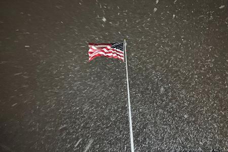 Eine Flagge weht im Wind, während in Lowville in den USA Schnee fällt.