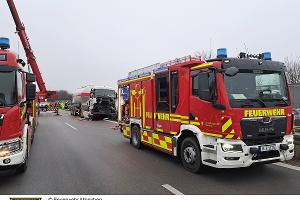 Im Vordergrund stehen Einsatzfahrzeuge der Feuerwehr, im Hintergrund ein verunfallter Lkw.