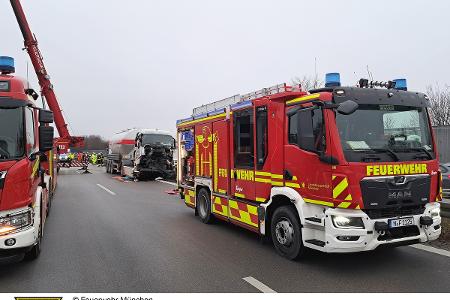 Im Vordergrund stehen Einsatzfahrzeuge der Feuerwehr, im Hintergrund ein verunfallter Lkw.