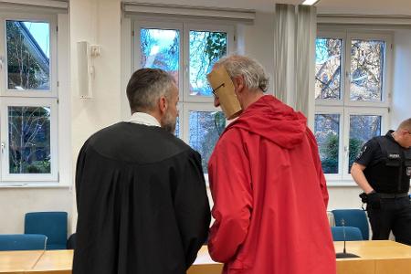 Der 53-jährige Angeklagte trug beim Betreten des Gerichtssaals eine augenscheinlich selbst gebastelte Papp-Maske, die sein Gesicht verdeckte.