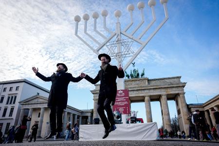 Yehuda Teichtal (l), orthodoxer Rabbiner, und Rabbi Shmuel Segal tanzen bei der Einweihung des Chanukka-Leuchters am Brandenburger Tor in Berlin.