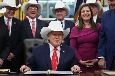 US-Präsident Donald Trump nimmt im Oval Office des Weißen Hauses in Washington an einer Zeremonie zur Unterzeichnung eines Gesetzentwurfs mit Mitgliedern des olympischen US-Eishockeyteams der Männer von 1980 teil und trägt einen Cowboyhut.