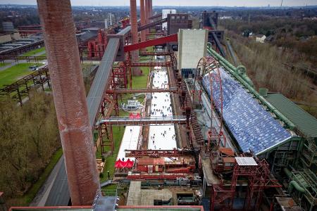 Menschen tummeln sich auf der Eisbahn in der Zeche Zollverein in Essen. 