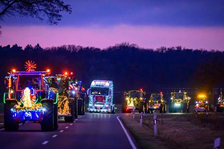 Weihnachtlich beleuchtete und geschmückte Traktoren und Lkw sind bei der Lichterfahrt der Oderlandbauern in Brandenburg unterwegs. 