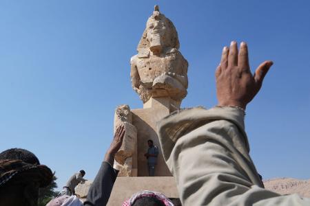 Arbeiter der Antikenverwaltung feiern, nachdem sie eine riesige Alabasterstatue für den Pharao Amenhotep III. in Luxor enthüllt haben.