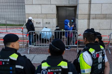 Menschen warten vor dem West Kowloon Magistrates' Courts auf die Urteilsverkündung gegen den Hongkonger Aktivisten und Verleger Jimmy Lai.