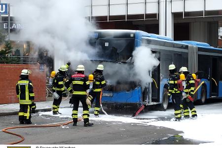 Einsatzkräfte der Feuerwehr München bei einem brennenden Linienbus.