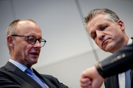 Friedrich Merz und Thorsten Frei mit einem Blick auf die Uhr