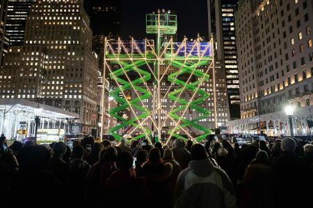 Menschen beobachten das Anzünden der weltgrößten Menora auf der Fifth Avenue.