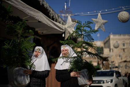 Orthodoxe Christinnen holen Weihnachtsbäume in Jerusalems Altstadt ab